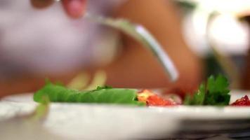 aan het eten vers groenten, aan het eten een vers groente salade gemaakt met groen groenten, selectief focus video