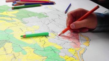 University student painting city plan maps, university student draws and colors city plan map, selective focus video