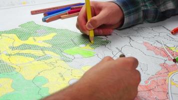 estudiantes haciendo mapas para ciudad planificación y estudiantes colorante el mapa, estudiantes quien dibujar arriba el mapa de el ciudad para arquitectura y urbano planificación, color el mapa, selectivo atención video