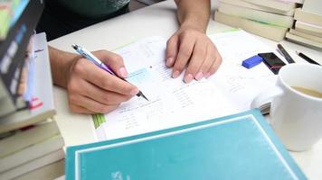 leerling voorbereidingen treffen voor tentamen door aan het studeren Bij studie bureau, leerling aan het studeren lost op de test vragen naar bereiden voor de examen, selectief focus video