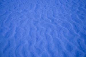 blue background with sand in the shape of sand waves photo