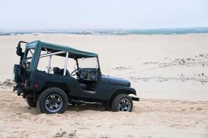 Jeep car with white sands. Vietnam desert,Popular tourist attractions in South of Vietnam. photo