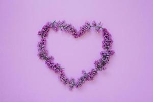corazón conformado marco de lila flores en un de colores antecedentes con un Copiar espacio. San Valentín día, primavera tiene ven foto