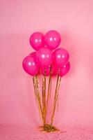 Festive fuchsia or pink balloons with gold threads, collected in a bouquet for a birthday, Valentine's Day or mom's Day photo