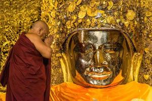 mandala, myanmar - jul 17, 2018-senior monje lavar el cara de Mahamuni Buda imagen a Mahamuni templo. el más muy venerado Buda imagen en el país. foto