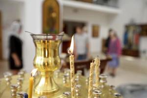 Iglesia velas en el antecedentes de borroso gente. foto