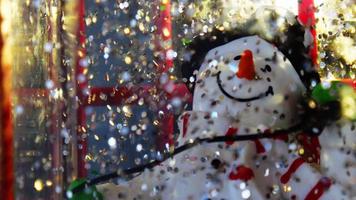 brillante contento pupazzo di neve palla con bokeh fiocco di neve, allegro Natale e nuovo anno celebrare festivo scintillare sfera giocattolo video