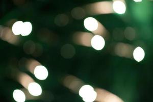 Festive background white blurred bokeh spots on green background. photo