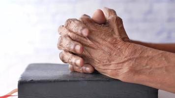 senior women holding a bible in his hands and praying. video