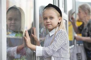 A little girl in the city smiling at the camera. photo