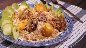 dichtbij omhoog van schapenvlees biryani maaltijd in een bord Aan tafel video