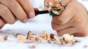 Person sharpens pencil to use, pencil waste comes out of the sharpened pencil, selective focus video