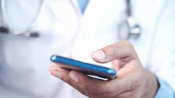 medico in camice bianco utilizzando uno smartphone video