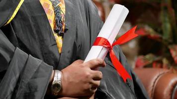 Student holding a graduation certificate video