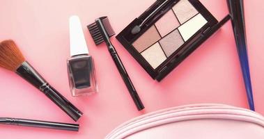 Top view of decorative black color cosmetic on pink background video