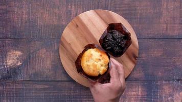 Close up of person hand picking chocolate and blueberry cup cake , video