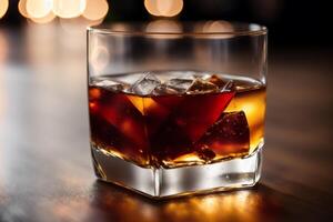 Glass of whiskey on the rocks with ice cubes on a wooden table, close-up. photo