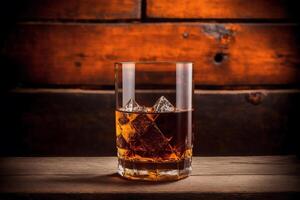 Glass of whiskey on the rocks with ice cubes on a wooden table, close-up. photo