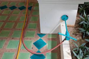 exterminate termite control company employee is using a termite sprayer at customer's house and searching for termite nests to eliminate. exterminate control worker spraying chemical insect repellant photo