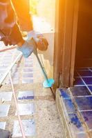 exterminate termite control company employee is using a termite sprayer at customer's house and searching for termite nests to eliminate. exterminate control worker spraying chemical insect repellant photo