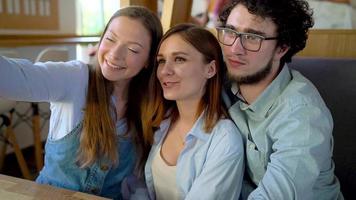 joven amigos sentar en un cafetería, bebida café y tener divertido comunicado. lento movimiento video