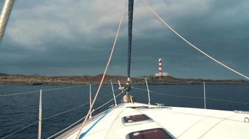 Aussicht von das Deck von das Yacht, welche steht in der Nähe von das Küste mit das Leuchtturm. Teneriffa, Kanarienvogel Inseln video