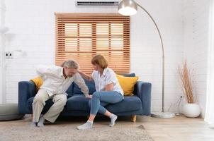 An elderly couple with a husband suffering from back pain without children to look after, everyone must help and look after each other. photo