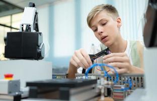 jovenes utilizando el mano robot tecnología son teniendo divertido aprendizaje el mano robot controlador de robot tecnología, cuales es uno de el vástago cursos foto