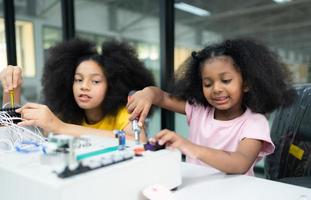 Children using the hand robot technology and having fun Learning the electronic circuit board of hand robot technology, which is one of the STEM courses. photo