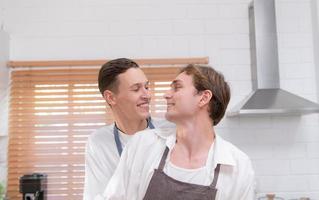 A young couple enters the kitchen to prepare dinner for celebrating the anniversary of being together for many years photo