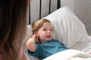 Little boy's mother read stories to children before going to bed to unwind and sleep soundly until the morning. photo