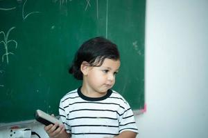 un pequeño chico con un brillante imaginación es claramente visible en el pizarra foto