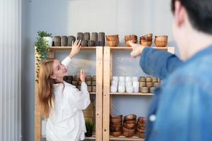 A young couple runs a small business making clay jewelry. They support one another as they work toward becoming larger business in the future. photo