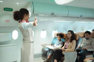 Flight attendants show how to use safety devices and recommend emergency exits. photo