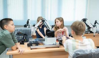 niños utilizando el mano robot tecnología, estudiantes son estudiando tecnología, cuales es uno de el vástago cursos foto