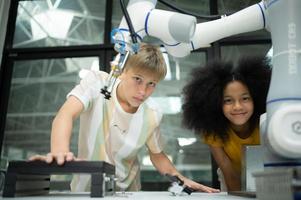 niños utilizando el mano robot tecnología, estudiantes son estudiando tecnología, cuales es uno de el vástago cursos foto