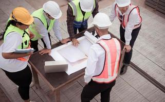 Construction engineers, architects, and foremen form a group. Participate in a meeting to plan new construction projects. photo