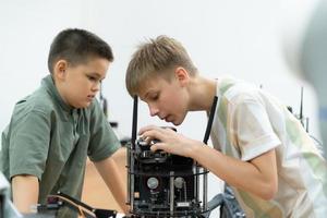 niños utilizando el mano robot tecnología, estudiantes son estudiando tecnología, cuales es uno de el vástago cursos foto