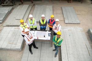 construcción ingenieros, arquitectos, y capataces formar un grupo. participar en un reunión a plan nuevo construcción proyectos foto