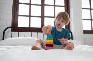 Little boy in his bedroom with a new toy purchased by his parents to help him improve his thinking skills. photo