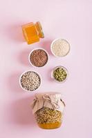 Healthy mixture of honey and various seeds in a jar and ingredients for cooking top and vertical view photo