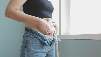 Bauch stecken, schlaff Haut auf ein Fett Bauch, Plastik Chirurgie Konzept auf grau Hintergrund video