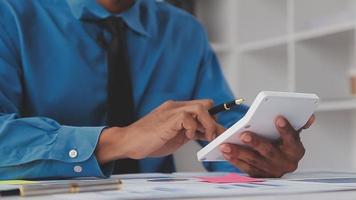 Financial analysts analyze business financial reports on a digital tablet planning investment project during a discussion at a meeting of corporate showing the results of their successful teamwork. video