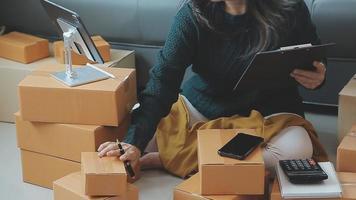 Business woman start up small business entrepreneur SME success .freelance woman working at home with Online Parcel delivery. SME and packaging deliveryconcept video