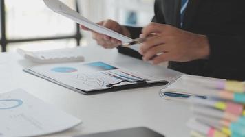 Financial analysts analyze business financial reports on a digital tablet planning investment project during a discussion at a meeting of corporate showing the results of their successful teamwork. video