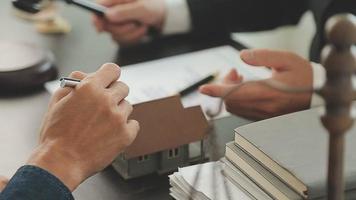 Business and lawyers discussing contract papers with brass scale on desk in office. Law, legal services, advice, justice and law concept picture with film grain effect video