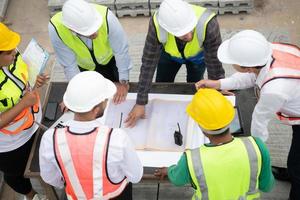 Construction engineers, architects, and foremen form a group. Participate in a meeting to plan new construction projects. photo