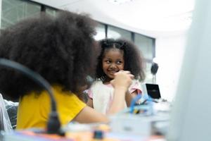 Children using the hand robot technology and having fun Learning the electronic circuit board of hand robot technology, which is one of the STEM courses. photo