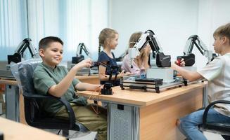 niños utilizando el mano robot tecnología, estudiantes son estudiando tecnología, cuales es uno de el vástago cursos foto