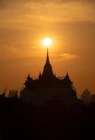 At a temple in the central of Bangkok Thailand, The morning sun will gradually move up to stand out at the end of this temple pagoda. This miracle happens only twice a year. photo